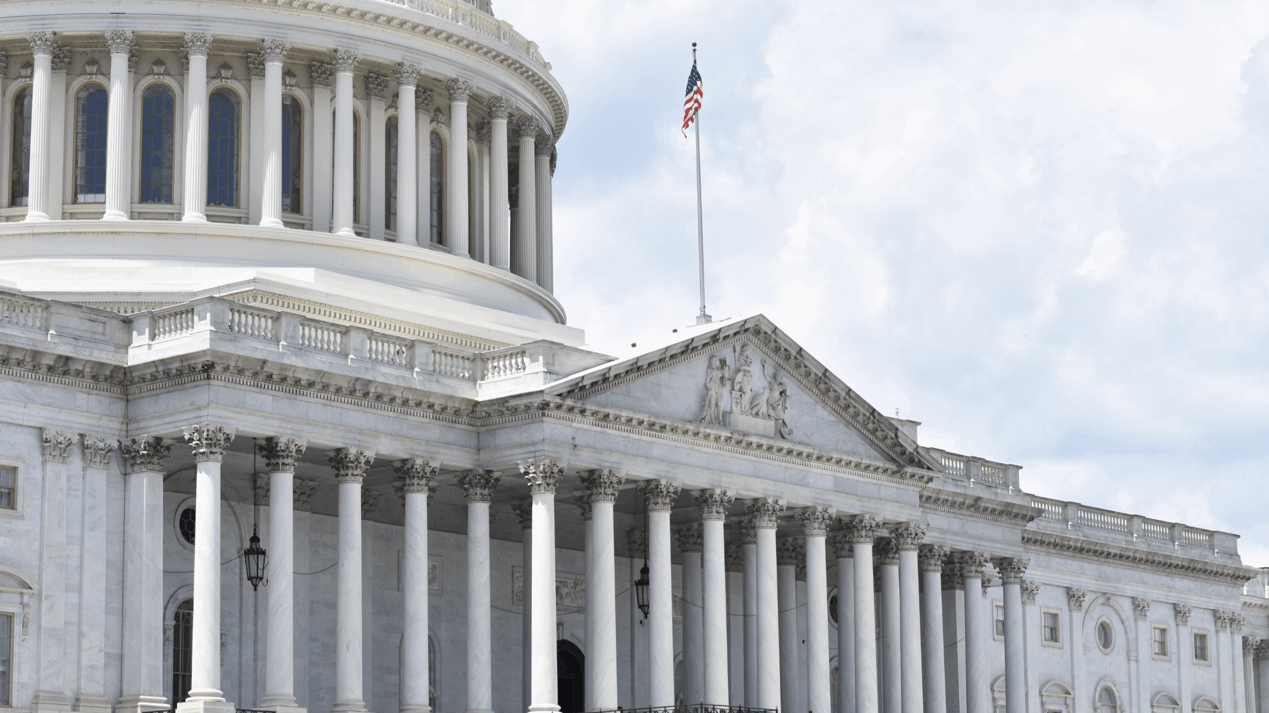 The U.S. Capitol dome and Senate wing under a partly cloudy sky